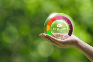 A human hand is holding a device for measuring air quality