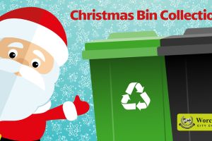 A cartoon-style image of Father Christmas standing next to green and black wheelie bins in a snow-covered landscape