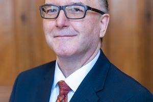 A man in a suit and tie, wearing glasses