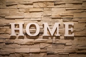 A sign saying 'home' showing on bricks