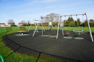 Swings and roundabouts in a play area within a park