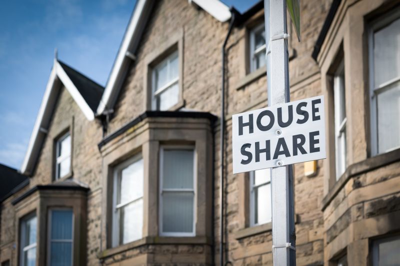 A house with a sign outside it that reads, "house share"