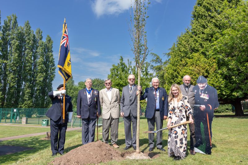 At the tree planting are (l-r) Howard Jones, Nigel Trigg, Roger Berry, Richard Jerrold, David Waldron, Councillor Mel Allcott, Graham London and a cardboard cutout of Jim London.