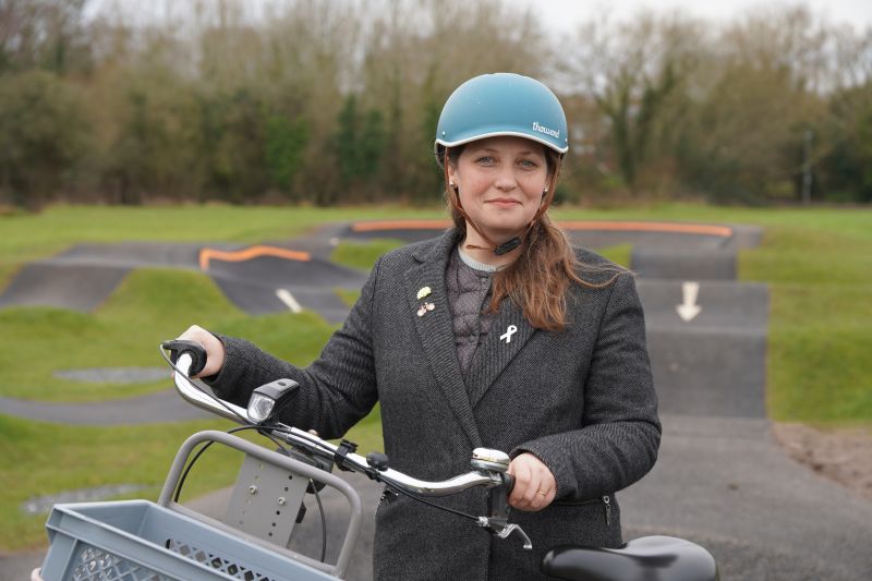 Councillor Hannah Cooper wearing a cycle helmet and holding a bike