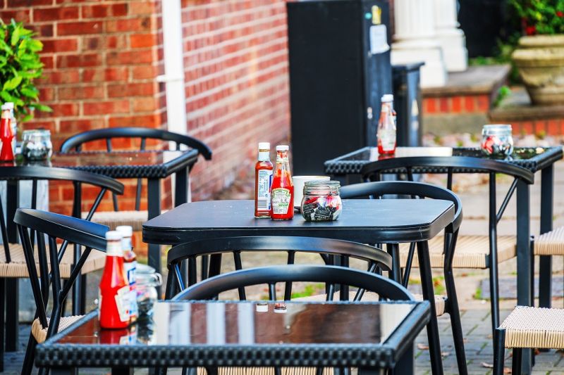 Tables and chairs in the street, outside a cafe