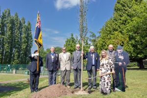At the tree planting are (l-r) Howard Jones, Nigel Trigg, Roger Berry, Richard Jerrold, David Waldron, Councillor Mel Allcott, Graham London and a cardboard cutout of Jim London.